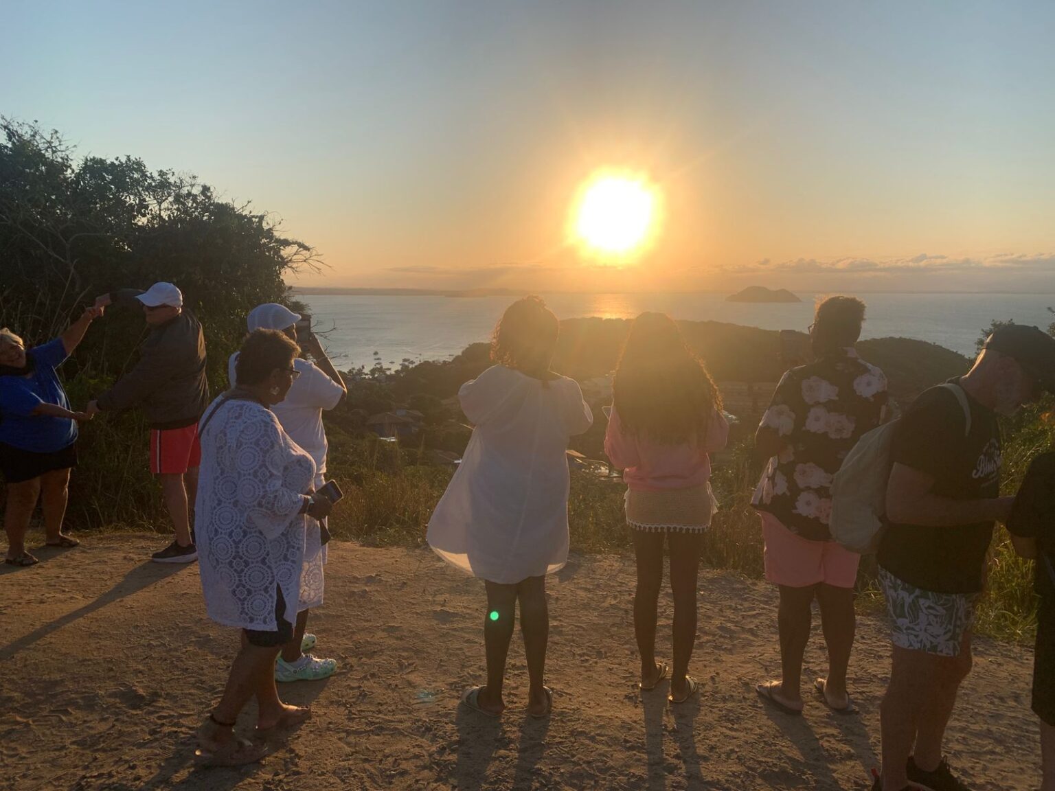 Group of travelers watching the sunset from a viewpoint in Búzios