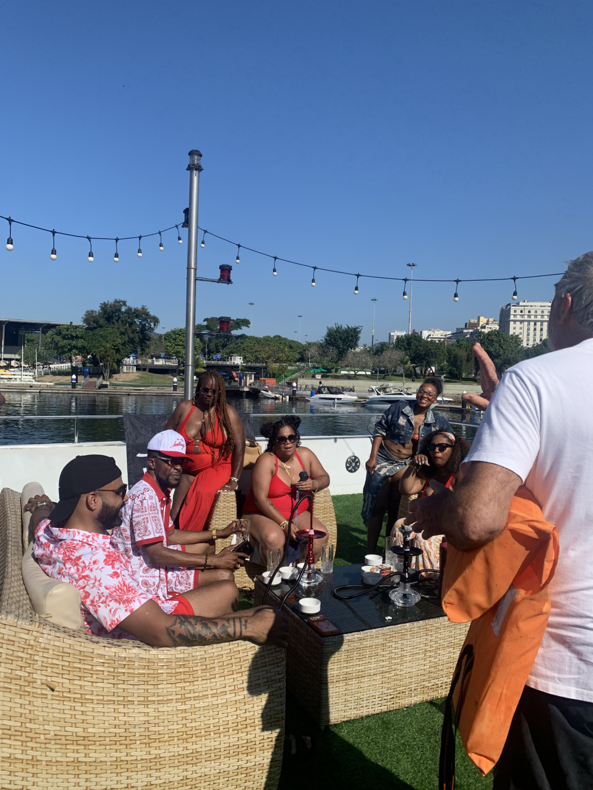 Friends sharing drinks on the outdoor lounge of a luxury catamaran in Rio de Janeiro