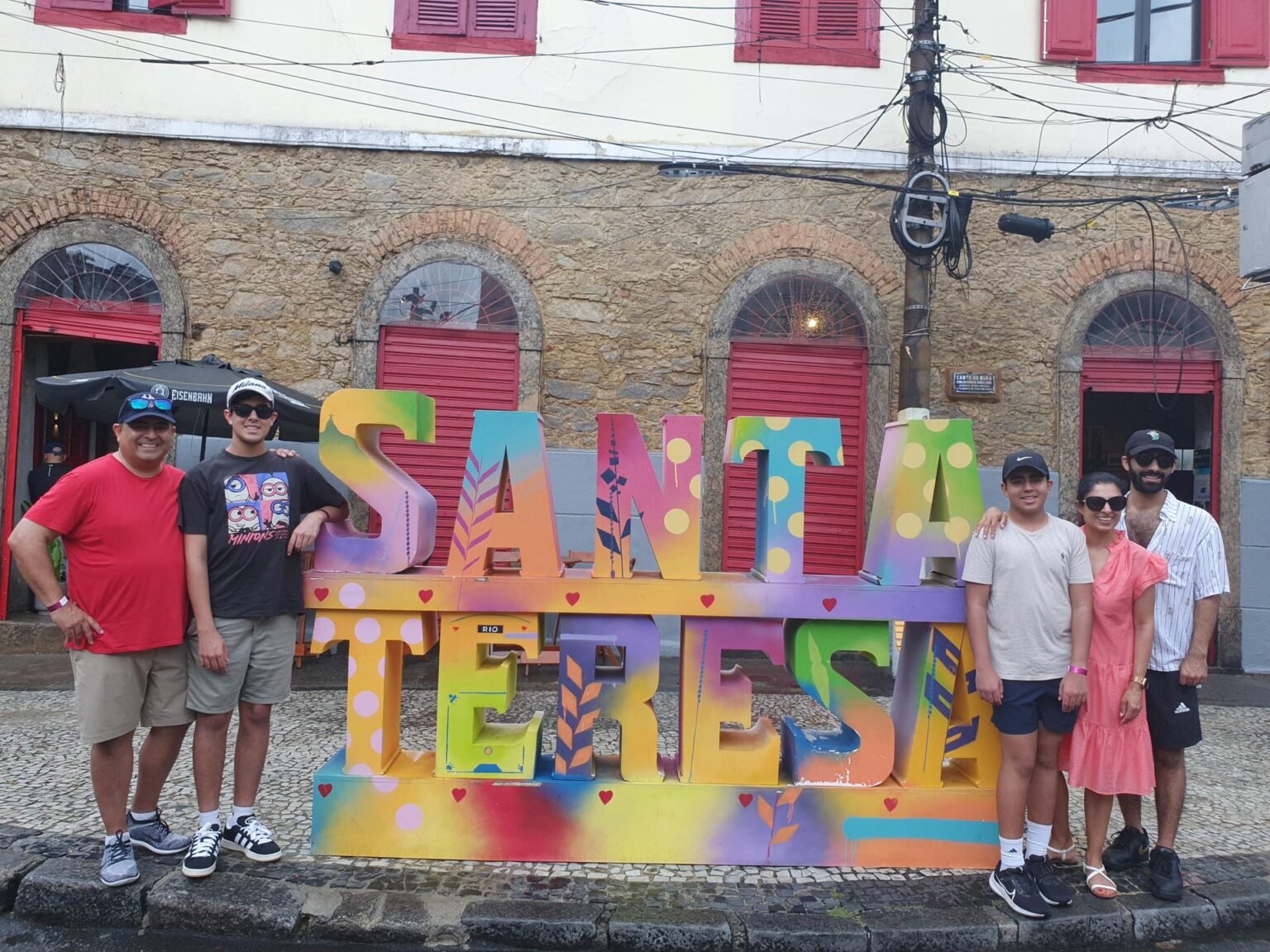 Travelers posing with the colorful Santa Teresa sign in Rio de Janeiro