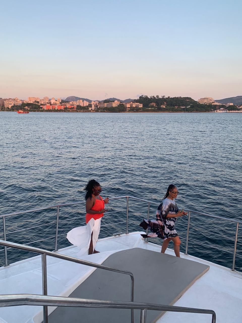 Travelers on the bow of a catamaran at sunset in Guanabara Bay