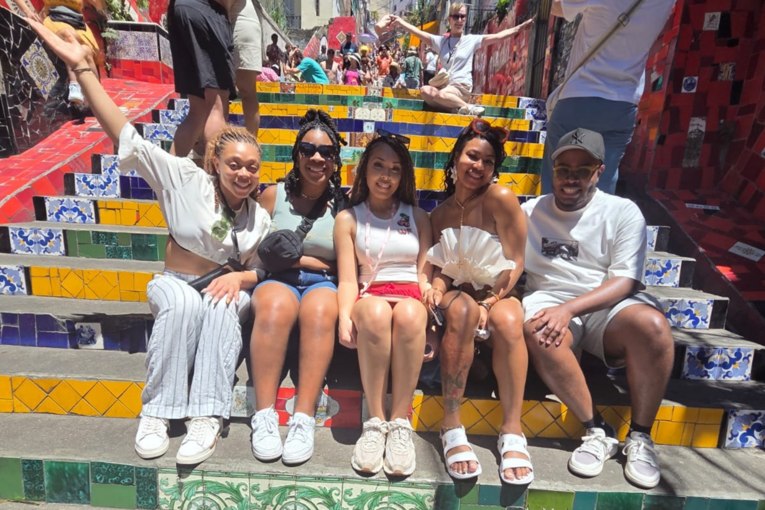 Group of travelers sitting on the colorful Selarón Steps in Rio de Janeiro