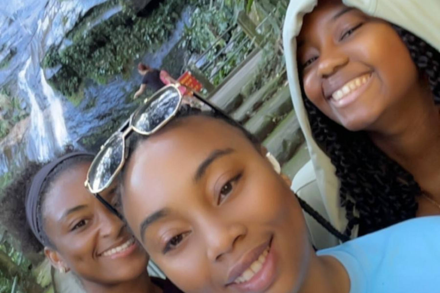 Friends taking a selfie by a waterfall in the Tijuca Forest, Rio de Janeiro