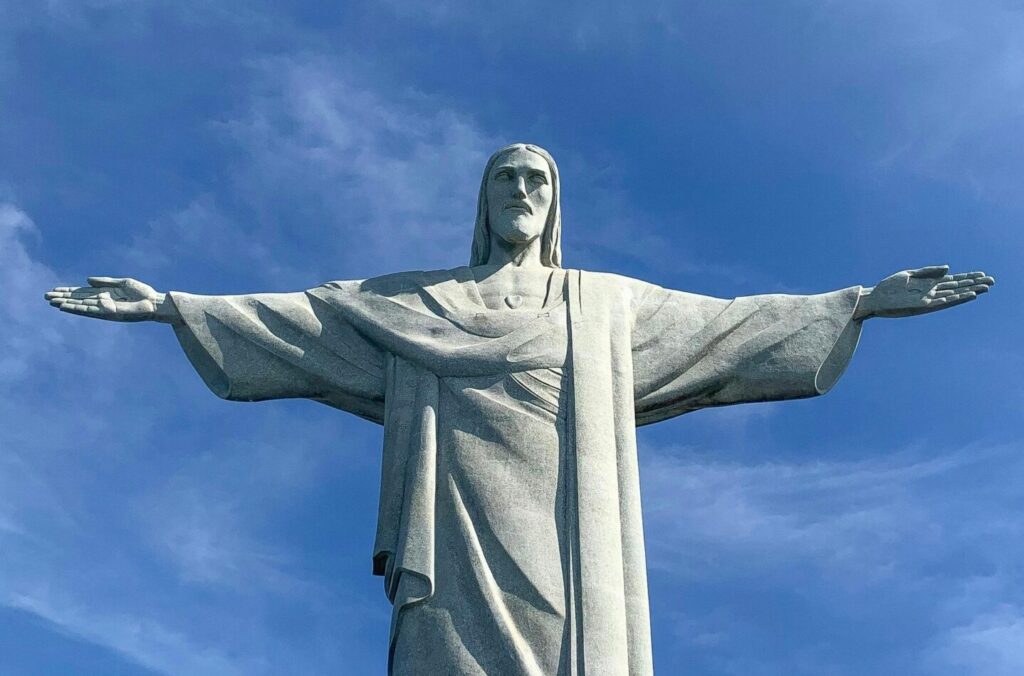 Christ the Redeemer statue with open arms against a blue sky in Rio de Janeiro